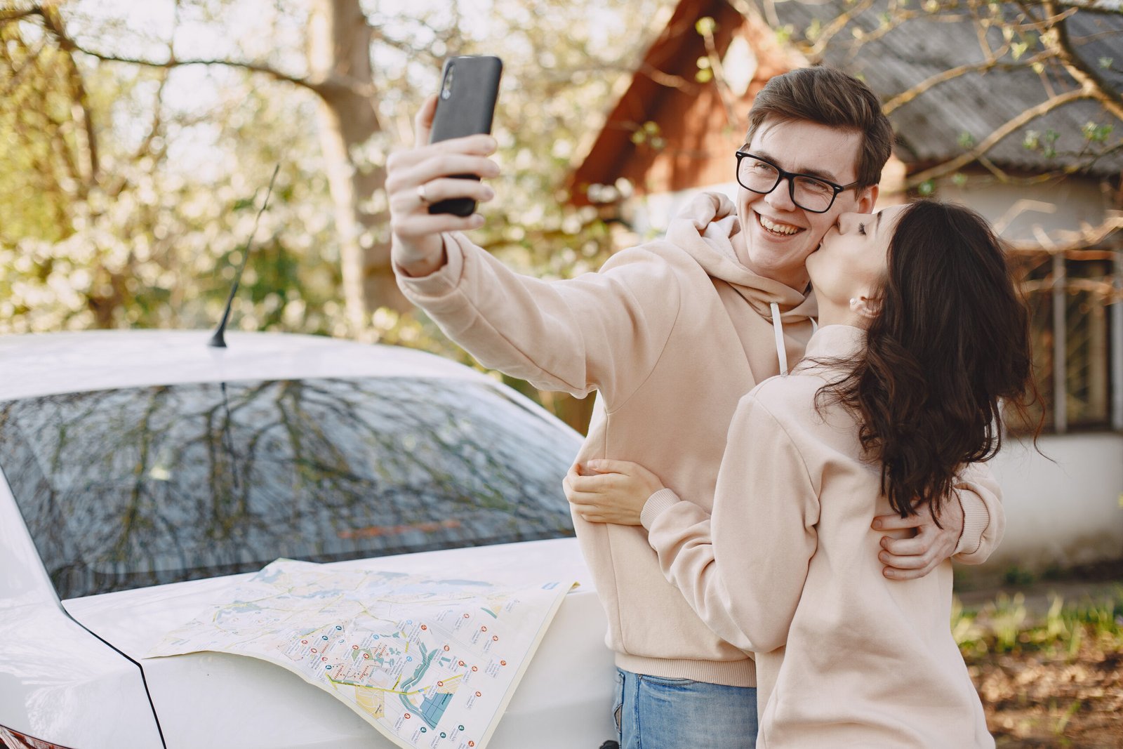 Couple in a park. People sitting on the hood. Pair with a map.