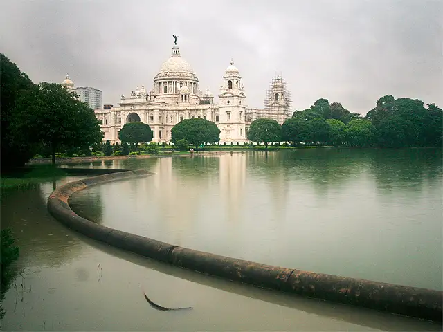 The image showcases the Victoria Memorial tomb along with its green surroundings and the lake