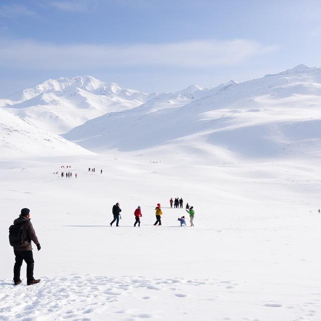 Snow-covered meadow in Gulmarg with tourists playing in the snow