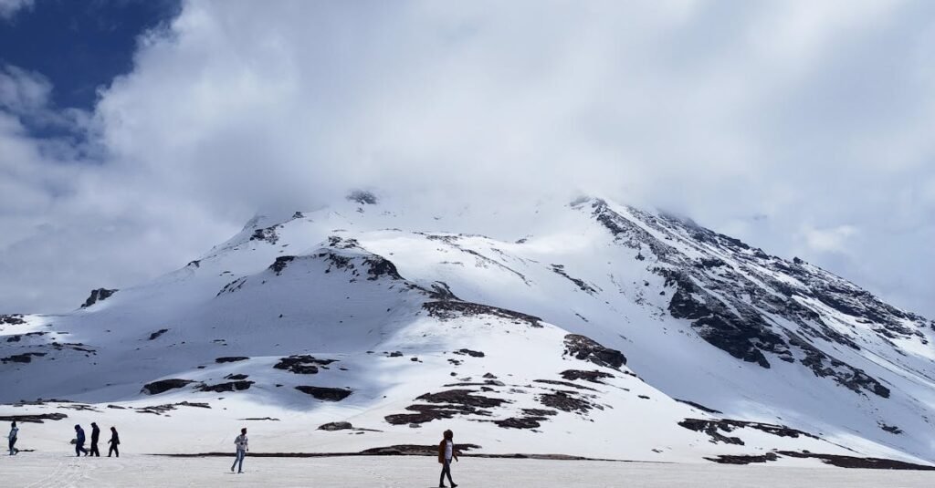 Scenic view of snow-capped peaks under cloudy skies in Rohtang, Himachal Pradesh.
