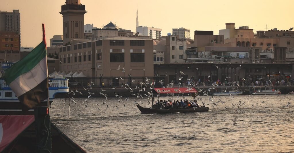 Vibrant view of Dubai Creek with a traditional boat, surrounded by seagulls and the city skyline in the background: Dubai tourist spots.