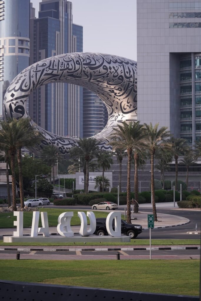 View of Dubai's iconic Museum of the Future with surrounding skyscrapers, palm trees, and urban scenery.