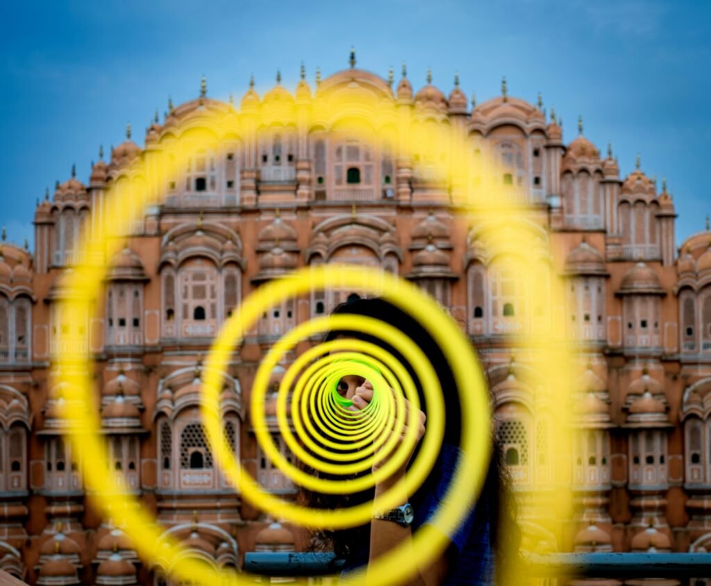 A colorful spiral art installation with Hawa Mahal, Jaipur as the backdrop, creating a vibrant visual.
