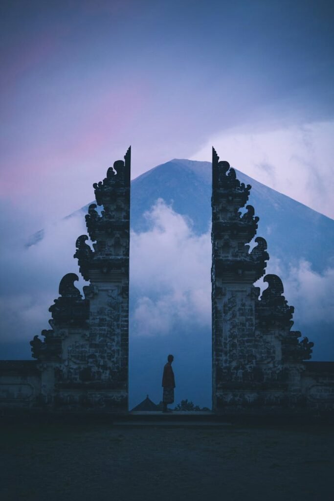 Silhouette at Pura Lempuyang Temple in Bali with Mount Agung in the background at twilight.